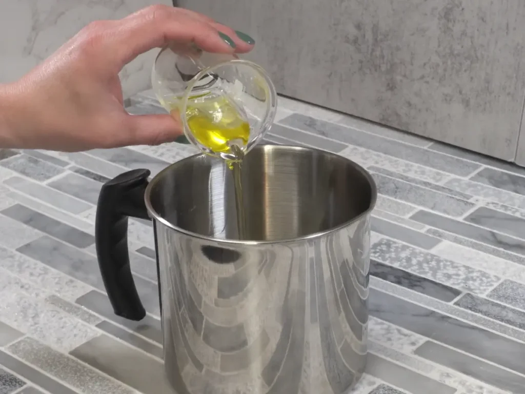 adding caster oil to massage candle