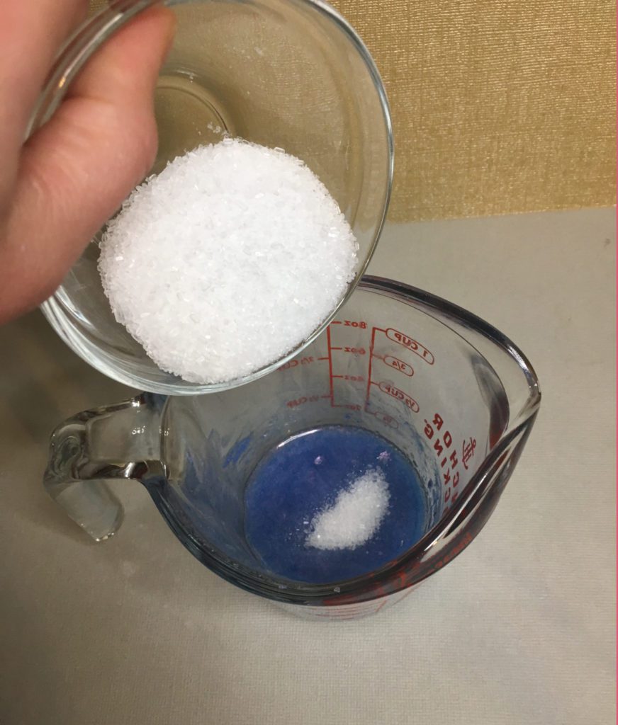 pouring epsom salt into scrub mixture