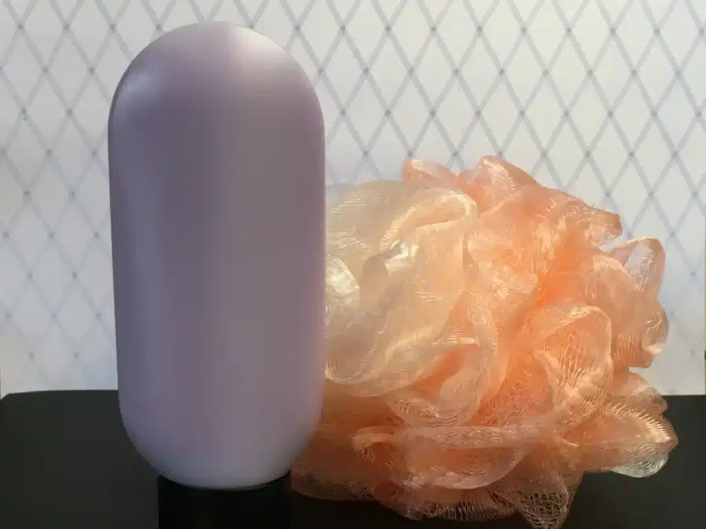 Finished body wash next to luffa sponge
