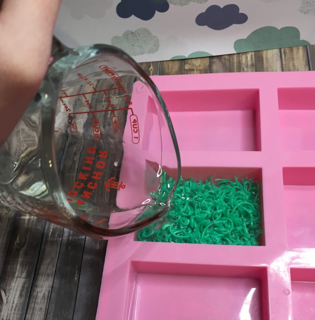 pouring clear soap over grass embed