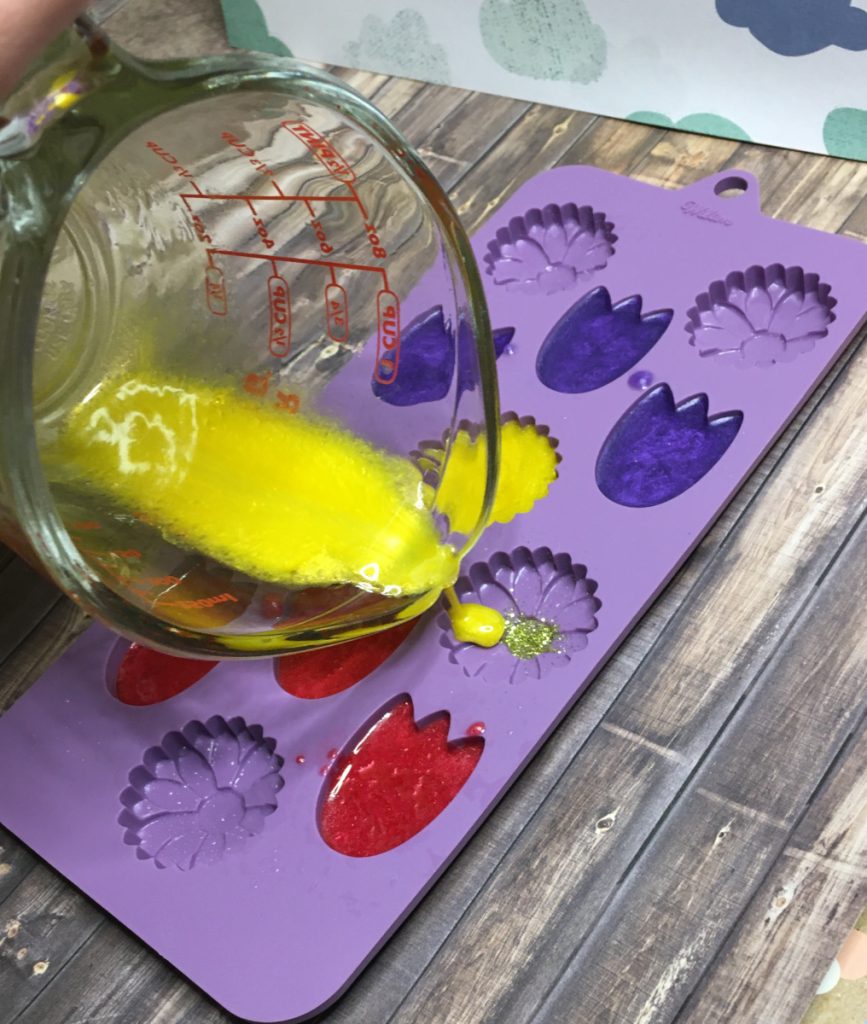 pouring yellow melt and pour into daisy embeds