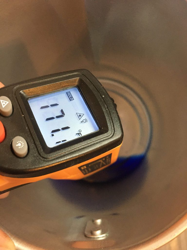 checking the temperature of soy way to ensure it is cool enough to add fragrance oil