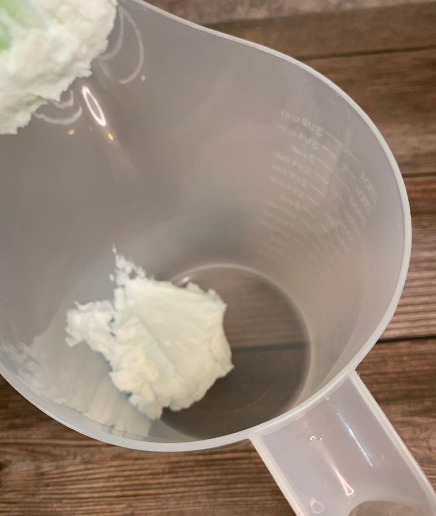 adding whipped soap base to mixing container