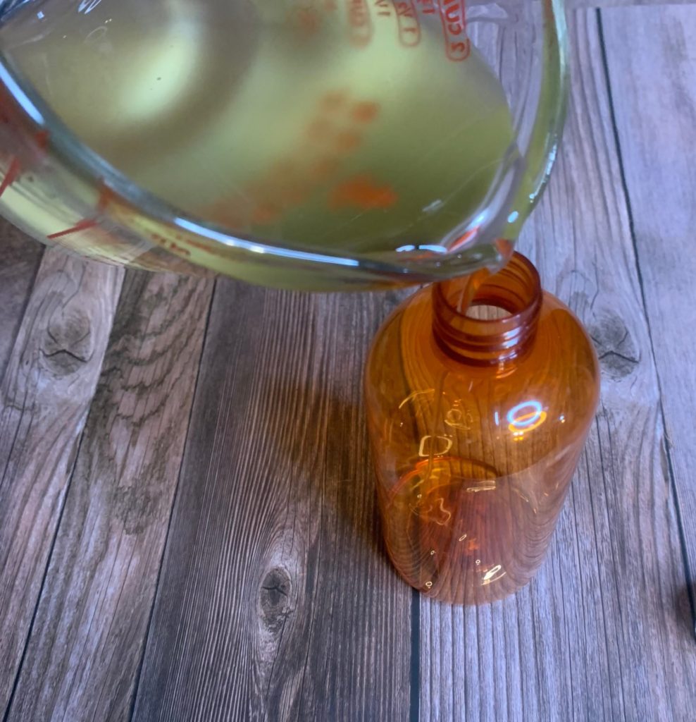 pouring blooming bath oil into container