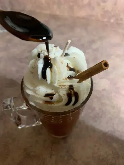 adding chocolate drizzle to whipped candle 