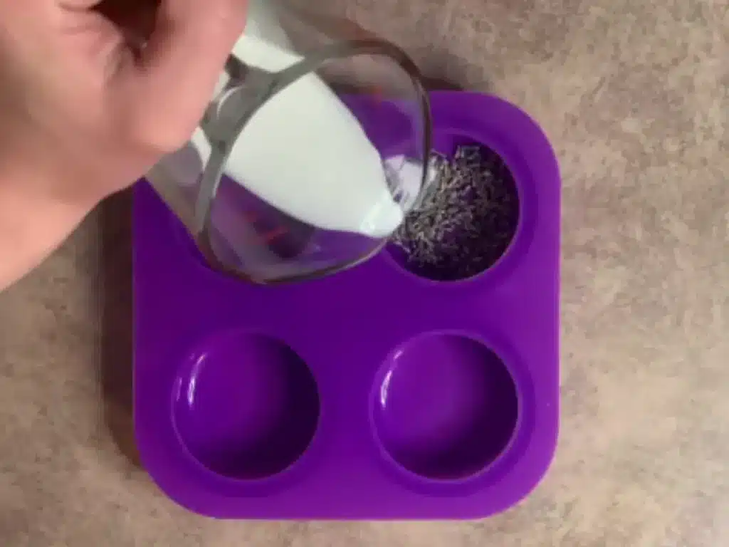 lavender buds on bottom silicone mold pouring melt and pour soap on top