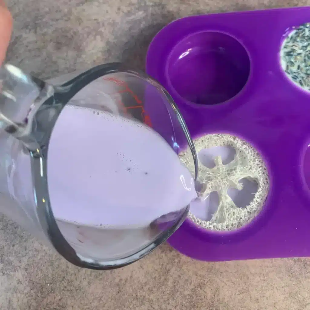 pouring soap into silicone mold with luffa in