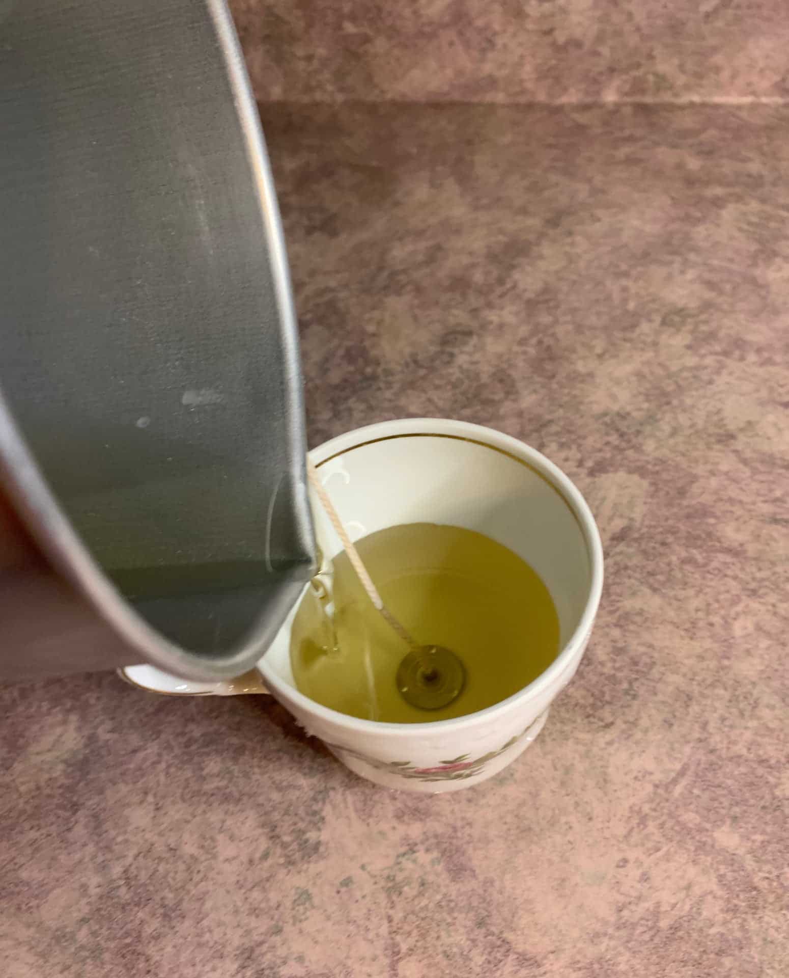 pouring candle wax into tea cup