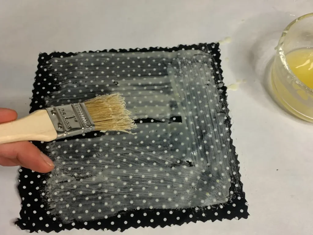 brushing beeswax mixture onto fabric for a food wrap
