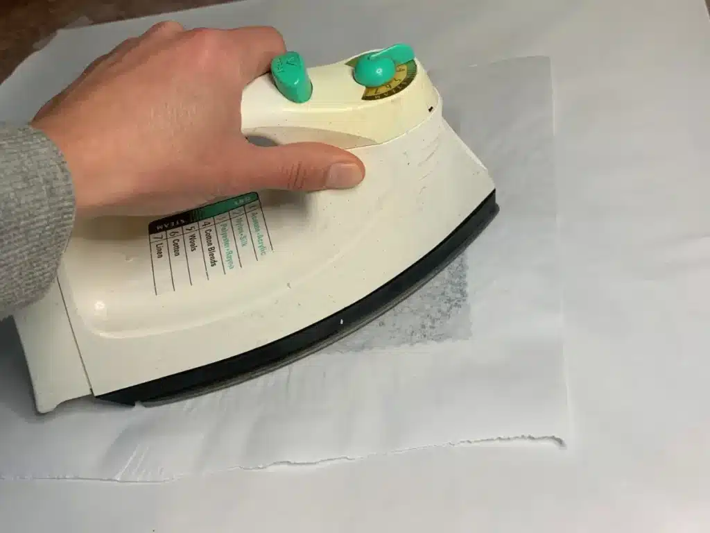 ironing beeswax mixture onto fabric for a food wrap