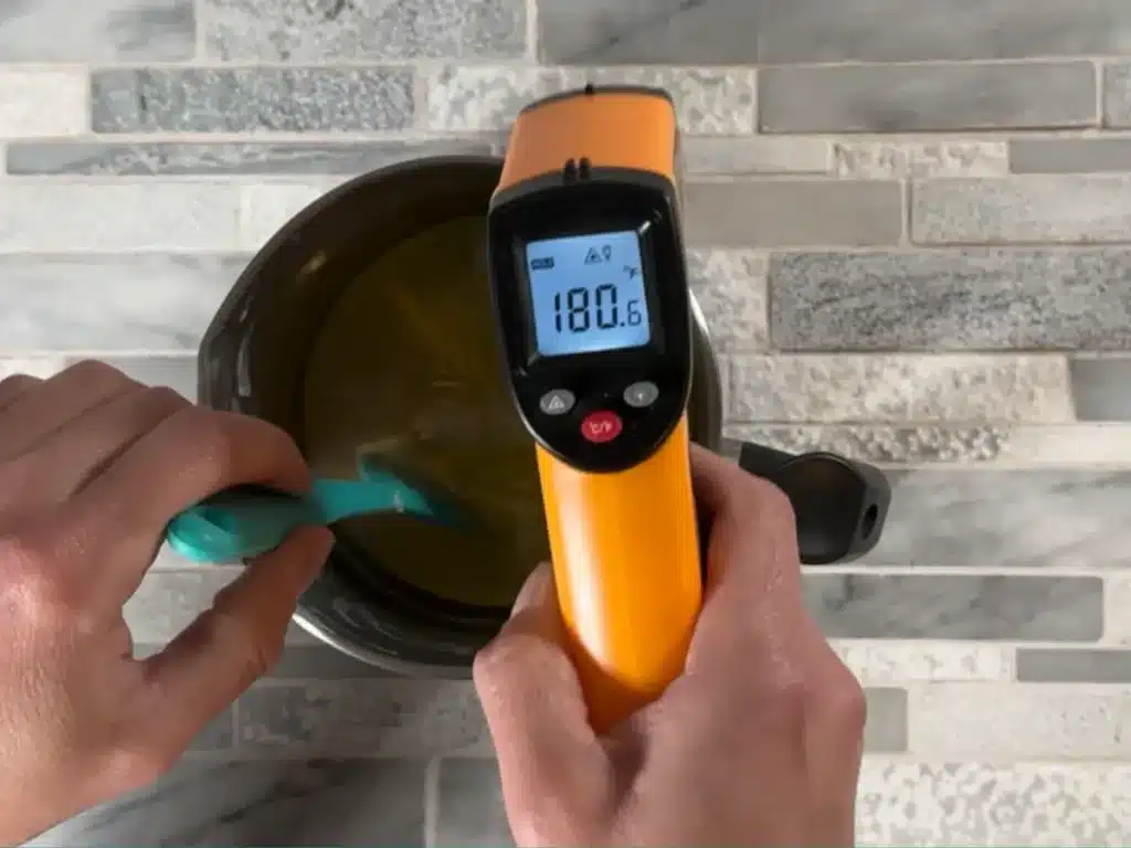 checking temperature of soy wax for making a candle