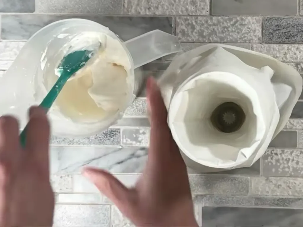 putting candle wax into a pipping bag to make decorative top