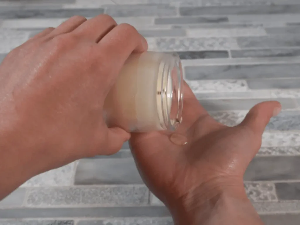 pouring massage oil candle onto skin