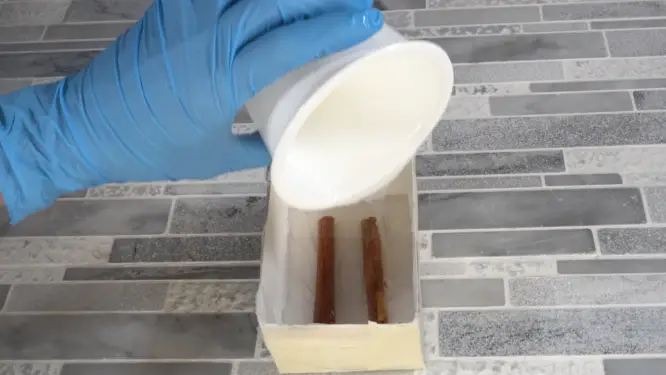 pouring silicone over cinnamon sticks
