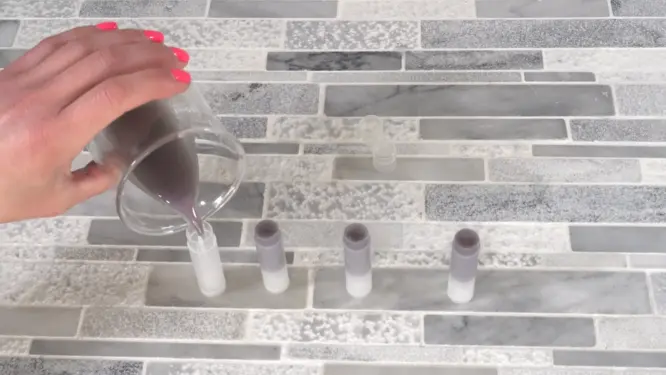 Pouring homemade lip balm into tubes