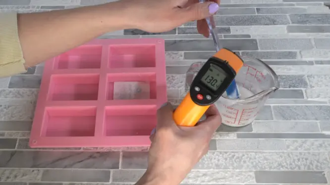 checking melt and pour soap temperature before pouring