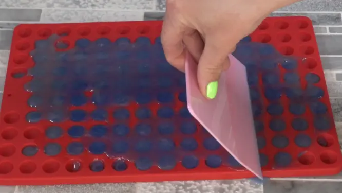pouring lotion dot mixture into silicone molds