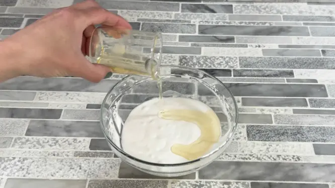 adding melted oils into whipped soap base during mixing process