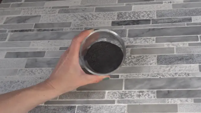 black hair dry shampoo with charcoal and cocoa powder in bowl