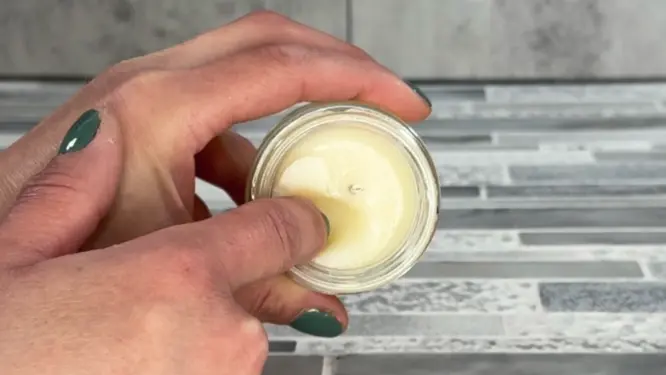 denting massage candle with finger to show how soft it is