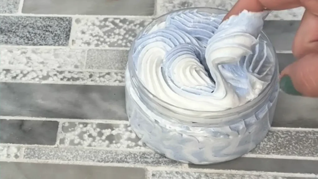 dipping finger into whipped soap to show final consistency