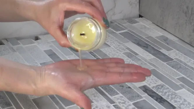 pouring massage oil candle on hand when not lit