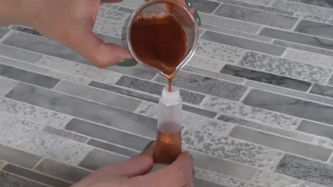 Pouring lip gloss into tube