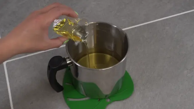 pouring fragrance oil into melted soy wax