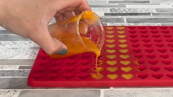pouring vegan lotion dots into heart mold