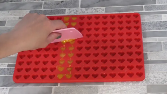 using scraper on lotion dot mold