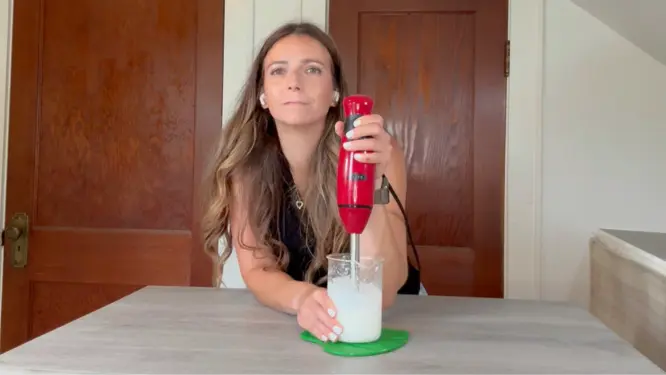 mixing natural lotion with an immersion blender