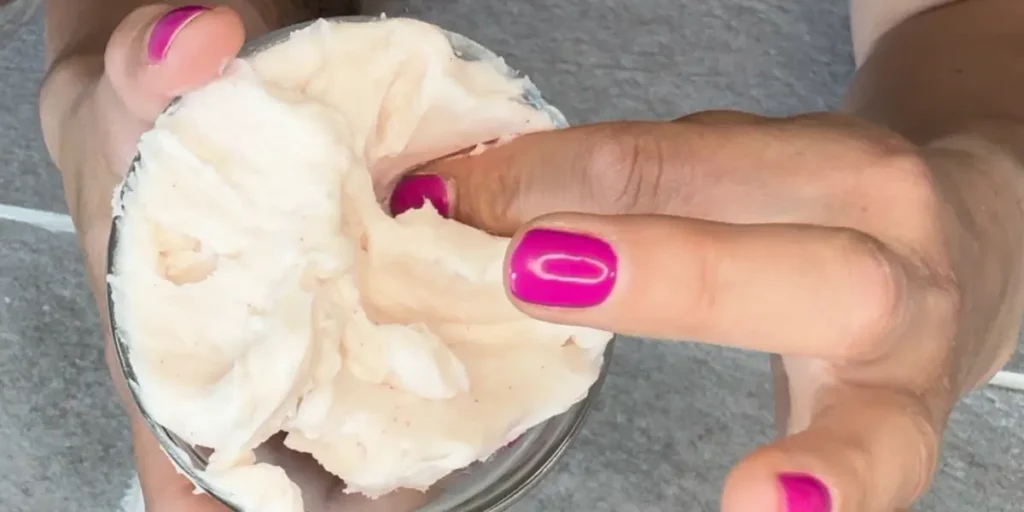 putting finger into body butter to show texture
