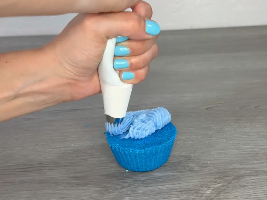 pipping frosting on a bath bomb cupcake