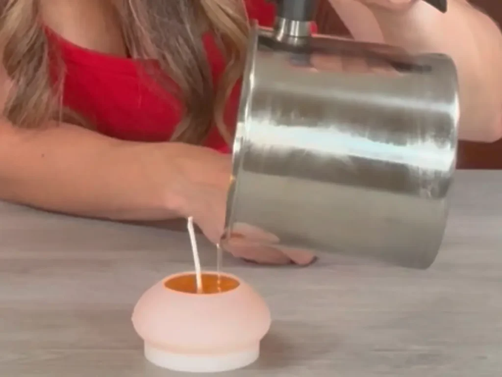 pouring wax into candle mold for floating candle