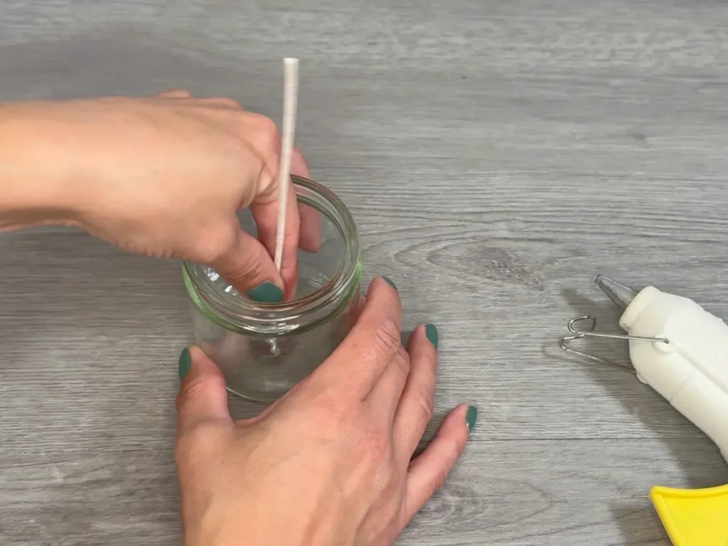 placing wick in candle jar