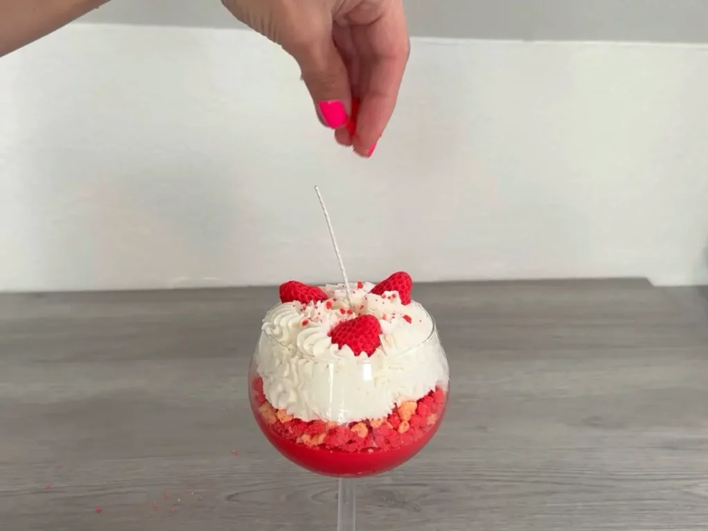 sprinkling wax crumble on top of candle