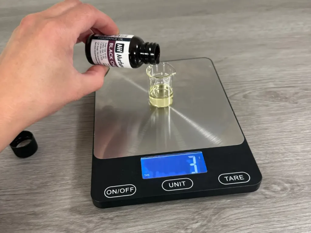 weighing fragrance oil for a candle